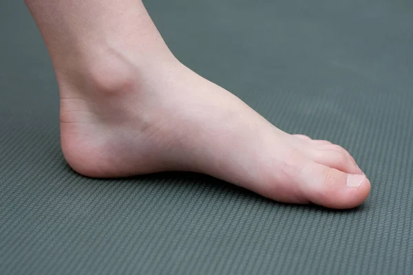 マットの上で裸足の子供 クローズアップの子供の足 サイドビュー 未就学児の平らな足の予防 — ストック写真