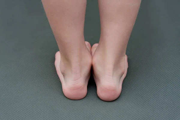 マットの上で裸足の子供 クローズアップの子供の足 バックビュー 未就学児の平らな足の予防 — ストック写真