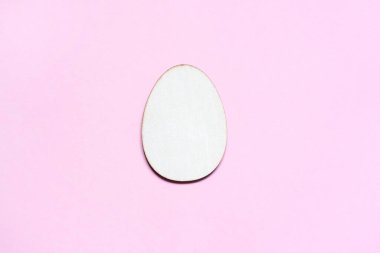 Pastel pembe arka planda yumurta şeklinde yaratıcılık için tamamen ahşap. Mutlu Paskalyalar. Tebrik kartı için maket, mesaj için boşluk. Üst görünüm, düz uzanma