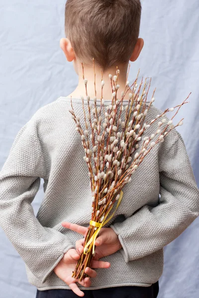 Chłopiec Chowa Bukiet Wiosennych Kwiatów Plecami Niebieskie Tło Dziecko Stojące — Zdjęcie stockowe