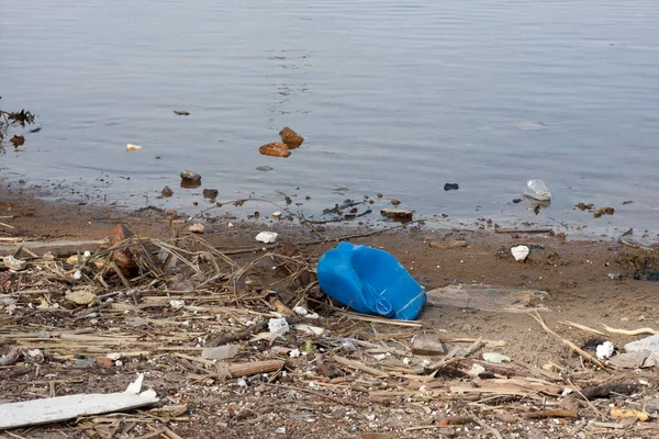 Garbage on banks of Dnieper River. Plastic trash, logs, styrofoam and other debris on the river bank. Ecological concept. earth day concept. globe pollution. Garbage on city beach.