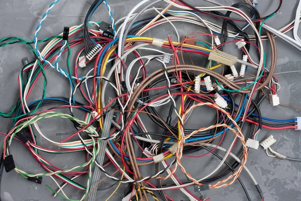 灰色混凝土背景上的彩色电缆和带连接器的电线 五彩缤纷的不同电脑和其他线路以及互联网组成的混乱 — 图库照片