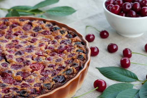 stock image Delicious cherry clafoutis in round baking dish on light background. Fresh homemade berry pie. Traditional French dessert. selective focus