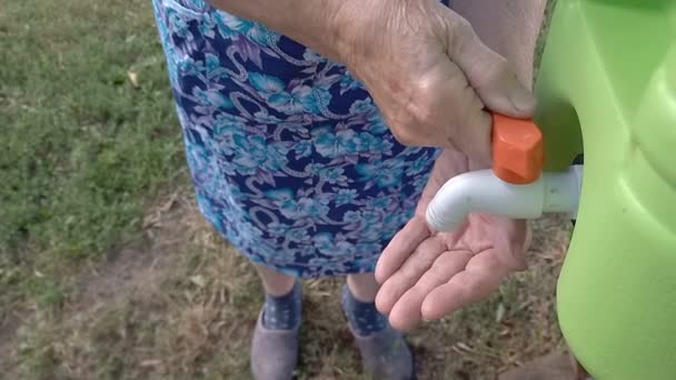 노부인은 통에서 씻는다 여자들 은물이 플라스틱 용기를 씻는데 세면대 여름에는 — 비디오