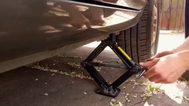 Otomobil tamircisi arabada lastik değiştirmek için vida kullanıyor. Araba tamiri ve bakımı. Hasarlı tekerlek değiştiriliyor. Yaz, açık hava