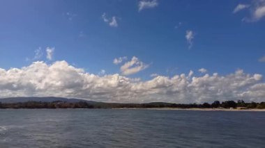 Güneşli yaz gününde resimli deniz manzarası. Kumsalın ve sakin denizin panoramik manzarası. Ormanla çevrili sahil kenarındaki otellerde. Bulgaristan, Kiten kasabası, Güney Sahili Karadeniz kıyısında tatiller