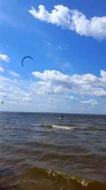 Profesyonel sörfçüler Ukrayna 'nın Kiev Reservoir şehrinde yazın sörf yapıyor. Aşırı su sporları. Su üzerinde uçurtma sörfü eğitimi. Uçurtmada adrenalin. dikey video