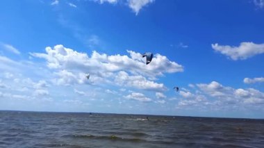 Profesyonel sörfçüler Ukrayna 'nın Kiev Reservoir şehrinde yazın sörf yapıyor. Aşırı su sporları. Su üzerinde uçurtma sörfü eğitimi. Uçurtmada adrenalin..