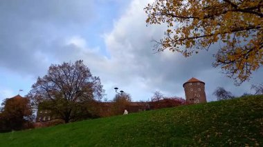 Wawel Hill 'deki kale kulesi ve kale manzarası. Turistler tarihi mimari kompleksi Krakow 'un ünlü simgesini ziyaret ettiler