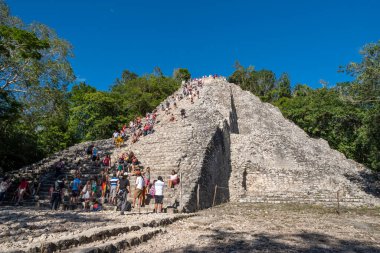Coba, Meksika - 12.23.2020: Meksika 'nın Coba-Antik Maya kenti. Yucatan Yarımadası arkeolojik alanı olan Coba' daki Nohoch Mul 'un tepesine tırmanan turistler.