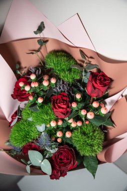 Kırmızı güller, böğürtlenler, dianthus yeşil topları içeren taze çiçek buketi.