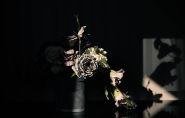 Koyu arkaplandaki yapay çiçek kompozisyonu. İç dekorasyon.