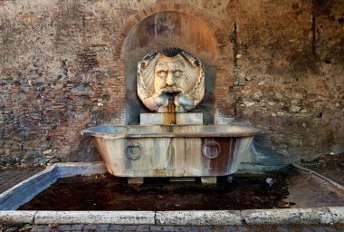 Roma, İtalya 'daki çeşmenin önünde kafası kafa şeklinde bir çeşmeye yakın bir yerde.