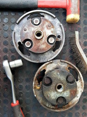 Paslı metal arka planda eski fren yastıkları ve aletler. Üst görünüm.