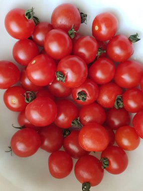 Beyaz arka planda yaprakları olan taze domatesler