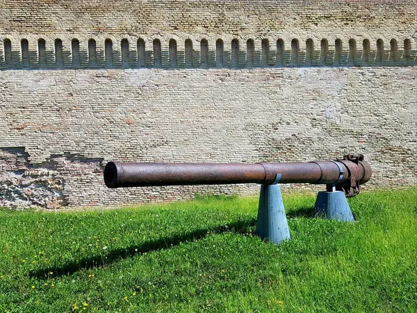 Kalenin duvarındaki yeşil çimlerin üzerinde eski bir top..