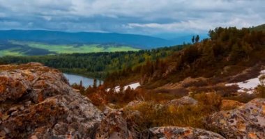 Dağ Gölü yaz ya da sonbahar zamanında zaman atlaması. Vahşi doğa ve kırsal alan. Hızlı bulutlar, yeşil çimenler ve dramatik gökyüzü. Motorlu doli kaydırma hareketi