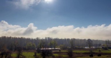 Sonbahar gündoğumu saatinde 4k dağlık çayır zamanı. Vahşi doğa ve çim tarlasında kırsal samanlıklar. Sabah sisi, güneş ışınları ve ağaçlar. Motorlu doli kaydırıcı