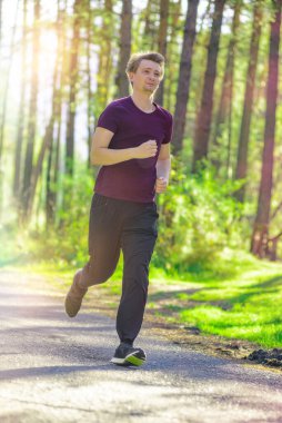 Koşan adam güzel bir yaz gününde şehir parkında koşuyor. Spor fitness modeli Kafkasya etnik köken eğitimi.