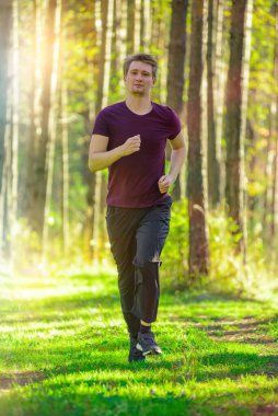 Koşan adam güzel bir yaz gününde şehir parkında koşuyor. Spor fitness modeli Kafkasya etnik köken eğitimi.