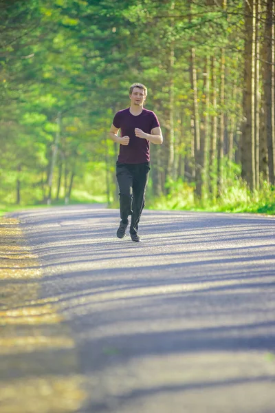 stock image Running man jogging in city park at beautiful summer day. Sport fitness model caucasian ethnicity training outdoor.