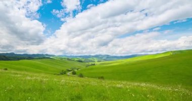 Yaz ya da sonbahar mevsiminde dağdaki çayır zaman atlaması. Vahşi doğa ve kırsal alan. Hızlı bulut hareketleri, yeşil çimenler ve güneş ışınları. Motorlu Panorama