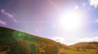4K UHD dağ çayırı zaman dilimi yaz ya da sonbahar zamanı. Vahşi Rus doğası ve kırsal alan. Bulutlar, ağaçlar, yeşil çimenler ve güneş ışınları hareketi.