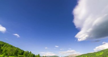 Yaz ya da sonbahar mevsiminde dağdaki çayır zaman atlaması. Vahşi doğa ve kırsal alan. Bulutların hareketi, yeşil çimenler ve güneş ışınları. Motorlu Panorama
