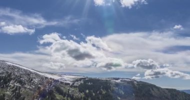 Dağların arkasındaki bulutların zaman çizelgesi. Kar, kayalar, uçurumlar ve derin mavi gökyüzü. Yüksek irtifa. Kamera hareketi.