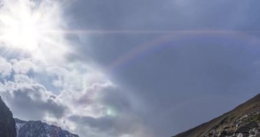 Yaz ya da sonbahar zamanı Dağ Vadisi 'ndeki destansı bulutların 4k UHD zaman çizelgesi. Vahşi sonsuz doğa ve kar fırtınası gökyüzü. Kar zirvesinde güneş ışınları. Hızlı hareket