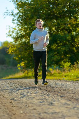 Koşan adam güzel bir yaz gününde kırsal alanda koşuyor. Spor fitness modeli Kafkasya etnik köken eğitimi.