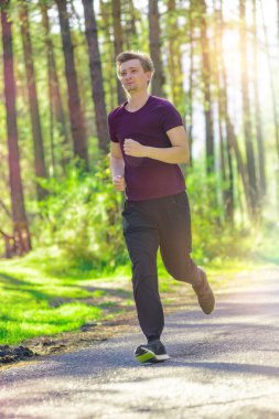 Koşan adam güzel bir yaz gününde şehir parkında koşuyor. Spor fitness modeli Kafkasya etnik köken eğitimi.