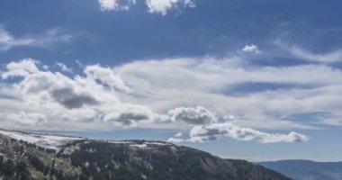 Dağların arkasındaki bulutların zaman çizelgesi. Kar, kayalar, uçurumlar ve derin mavi gökyüzü. Yüksek irtifa. Kamera hareketi.