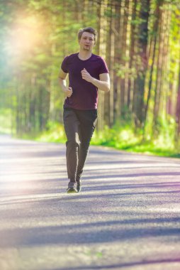 Koşan adam güzel bir yaz gününde şehir parkında koşuyor. Spor fitness modeli Kafkasya etnik köken eğitimi.