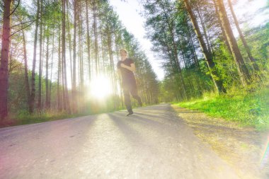 Koşan adam güzel bir yaz gününde şehir parkında koşuyor. Spor fitness modeli Kafkasya etnik köken eğitimi.