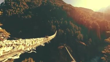 Khumbu vadisindeki en büyük asma köprü renkli Tibet dua bayraklarıyla. Vahşi Himalayalar yüksek irtifa doğa ve dağ vadisi. Ağaçlarla kaplı kayalık yamaçlar. Trek alanı ana kampa gidiyor.