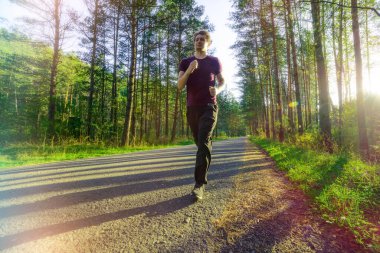 Koşan adam güzel bir yaz gününde şehir parkında koşuyor. Spor fitness modeli Kafkasya etnik köken eğitimi.