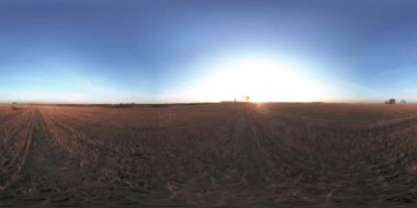 360 hava manzaralı. Güneşli bir sonbahar akşamında sonsuz yeşil tarlaları olan yaz manzarasının üzerinde alçak uçuş. Ufuktaki güneş ışınları. Hızlı yatay hareket. Tarım arazisi insansız hava aracı atışı. Dengeli