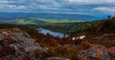 Dağ Gölü yaz ya da sonbahar zamanında zaman atlaması. Vahşi doğa ve kırsal alan. Hızlı bulutlar, yeşil çimenler ve dramatik gökyüzü. Motorlu doli kaydırma hareketi