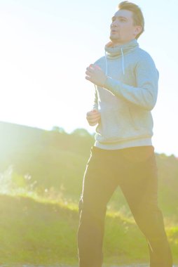 Koşan adam güzel bir yaz gününde kırsal alanda koşuyor. Spor fitness modeli Kafkasya etnik köken eğitimi.