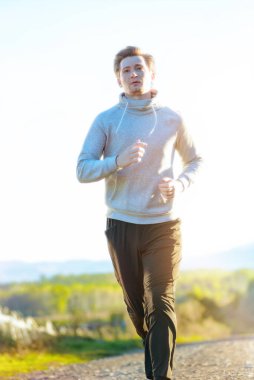 Koşan adam güzel bir yaz gününde kırsal alanda koşuyor. Spor fitness modeli Kafkasya etnik köken eğitimi.