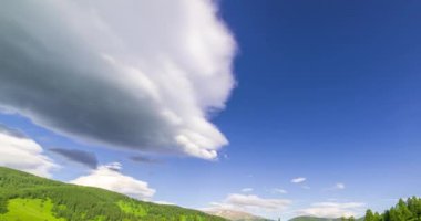 Yaz ya da sonbahar mevsiminde dağdaki çayır zaman atlaması. Vahşi doğa ve kırsal alan. Bulutların hareketi, yeşil çimenler ve güneş ışınları. Motorlu Panorama