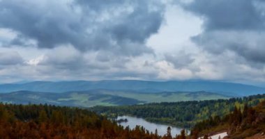 Dağ Gölü yaz ya da sonbahar zamanında zaman atlaması. Vahşi doğa ve kırsal alan. Hızlı bulutlar, yeşil çimenler ve dramatik gökyüzü. Motorlu doli kaydırma hareketi