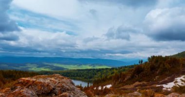 Dağ Gölü yaz ya da sonbahar zamanında zaman atlaması. Vahşi doğa ve kırsal alan. Hızlı bulutlar, yeşil çimenler ve dramatik gökyüzü. Motorlu doli kaydırma hareketi