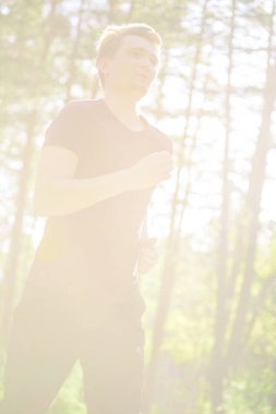 Koşan adam güzel bir yaz gününde şehir parkında koşuyor. Spor fitness modeli Kafkasya etnik köken eğitimi.