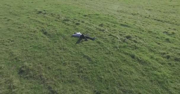 Высоты Птичьего Полета Низкоорбитальный Полет Вокруг Человека Лежал Зеленой Траве — стоковое видео
