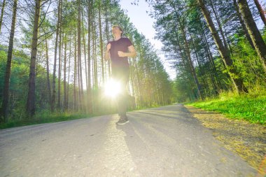 Koşan adam güzel bir yaz gününde şehir parkında koşuyor. Spor fitness modeli Kafkasya etnik köken eğitimi.