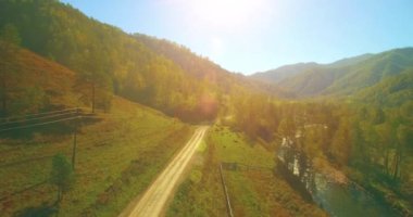4K hava bakış açısı. Güneşli yaz sabahında, taze, hızlı dağ nehri üzerinde kayalıklarla alçak irtifa uçuşu. Yeşil çam ağaçları ve güneş ışınları. Saf soğuk su akıntısı.