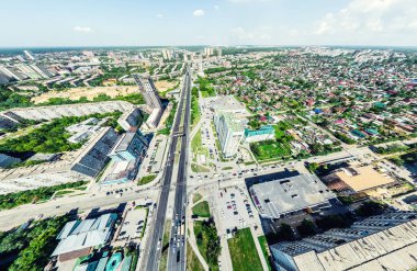Kesişen yollar, evler, binalar, parklar, otoparklar, köprüler olan havacılık şehri manzarası. Helikopter insansız hava aracı atışı. Geniş Panoramik resim.