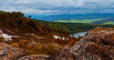 Dağ Gölü yaz ya da sonbahar zamanında zaman atlaması. Vahşi doğa ve kırsal alan. Hızlı bulutlar, yeşil çimenler ve dramatik gökyüzü. Motorlu doli kaydırma hareketi